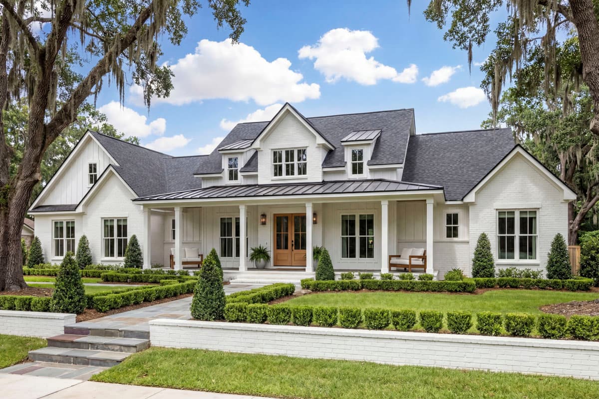 House plan exterior. Two-story Modern Farmhouse with a front porch, gables, and dormers. Features include a brick exterior and dark roof.