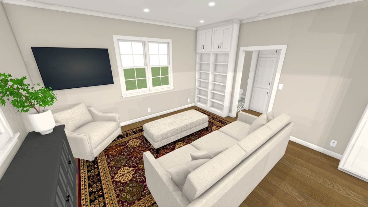 A furnished living room with a large TV, white furniture, a patterned rug, and a bookcase. Sunlight streams in through a window.