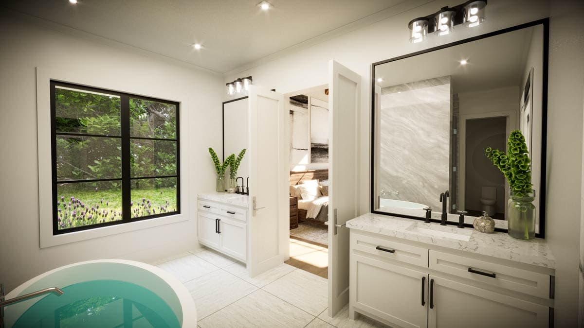 Luxurious bathroom with a view. Features a round tub, white vanity, large mirror, and open doorway to bedroom.