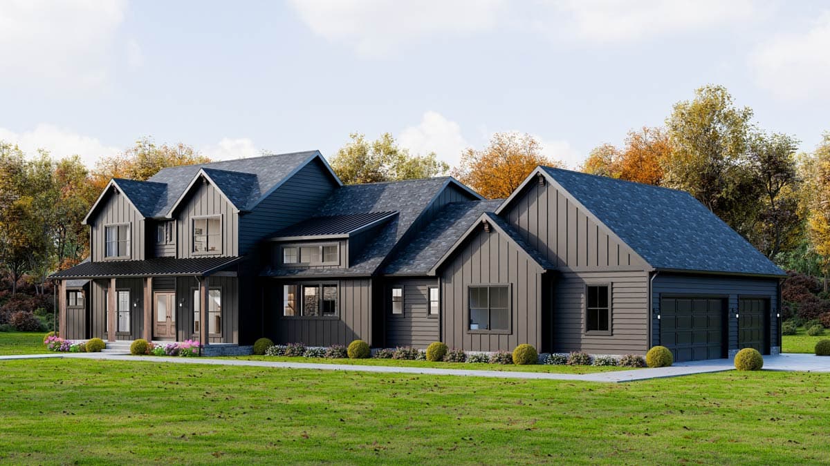 Modern two-story house with dark gray siding, multiple gabled rooflines, and a covered porch. Lush green lawn and autumn trees surround it.