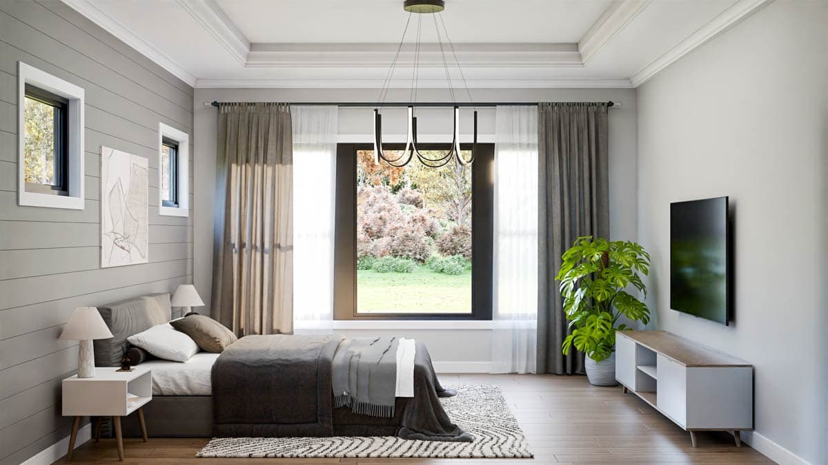 A modern bedroom with gray paneled walls, a large window with outdoor view, a bed, a TV, and a decorative plant in a pot.